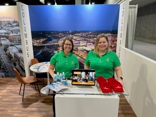 two smiling women at an informational booth